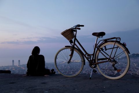 person sitting beside black and white rigid bike